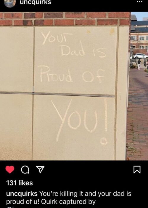 A screenshot of an IG post by UNCQuirks, showing a concrete wall on which is written, "Your Dad is proud of you." The caption on the post reads "